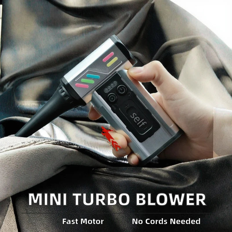 Hand holding a cordless mini turbo blower cleaning a car interior.